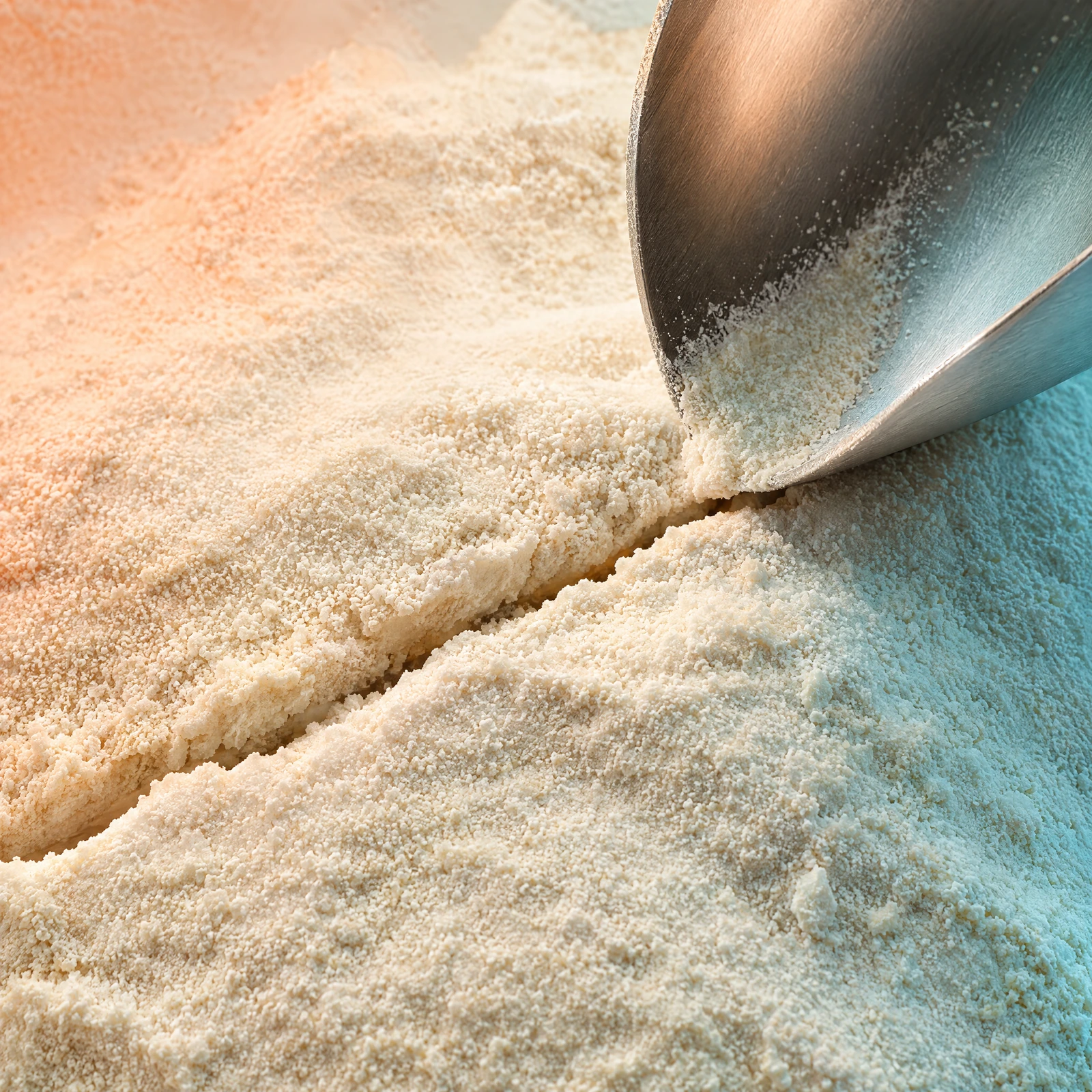 Close-up of whey powder with a narrow fissure and the edge of a scoop
